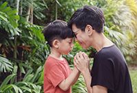 Mother and Child Holding Hands Facing Each Other Outside
