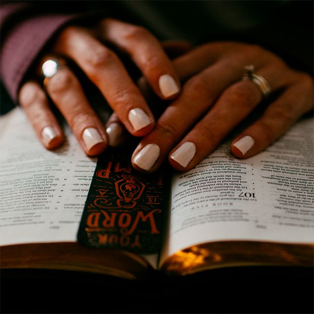 Hands resting on open scriptures. The reader is learning more about the life and teachings of Jesus Christ, our Savior and Redeemer.