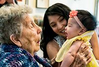 A grandmother cooing over her newborn granddaughter.