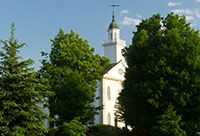 The Kirtland Temple peeking behind three trees.