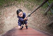 Young girl climbing a rope wall.