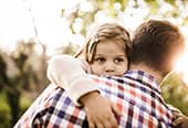 Little girl being comforted by her loving father.