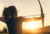 woman preparing to fire an arrow from a bow