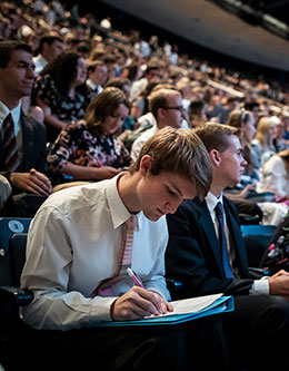 young man sitting in a crowd in the Marriott Center
