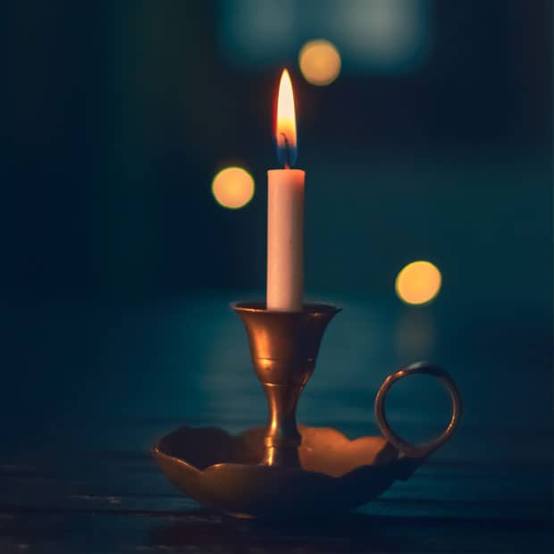 a candle burns, representing the guiding light of Jesus Christ