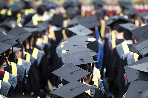 Rows of graduates sit preparing for graduation, commencement