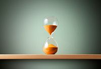 Hourglass with orange sand in it.
